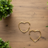 A pair of gold plate heart hoop earrings on a white background.