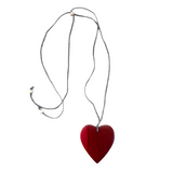 Necklace with a red heart pendant on a gray fabric background