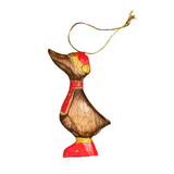 Small wooden duck ornament with a red base on a gray surface