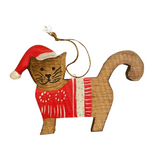 Wooden cat ornament wearing a red sweater and Santa hat on a white surface.