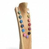 Colorful beaded necklace on a wooden stand against a blurred indoor background