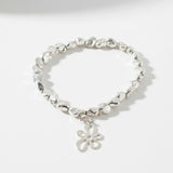 Silver bracelet with a flower charm on a white background