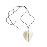 Heart-shaped pendant on a black cord against a white background