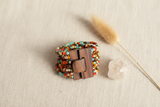 Colorful beaded bracelet with a wooden clasp on a white background