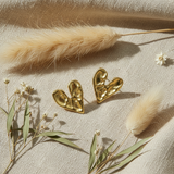 Gold heart-shaped earrings on a white background