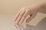 Hand wearing a gold ring on a white background