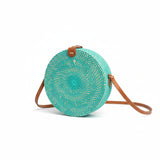 Round woven bag with brown strap on a white background