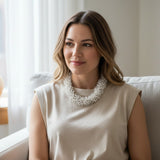 Suzie Blue Canada white beaded urchin necklace worn by a woman in a beige top, handcrafted in Bali.