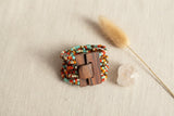 Suzie Blue Canada multi-strand seed bead bracelet with wooden clasp, featuring turquoise, orange, cream, and gold beads.