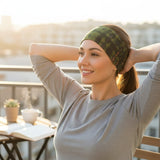 Woman wearing a green and black tie dye bandana headband from Suzie Blue Canada while relaxing on a sunny balcony.