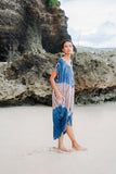 Suzie Blue Canada pink and blue tie-dye rayon kaftan dress with pockets, worn by a model on a beach.