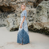 Suzie Blue Canada Tie Dye Lapis Ombre Maxi Dress in cream and grey 100% rayon with side slits on a beach.